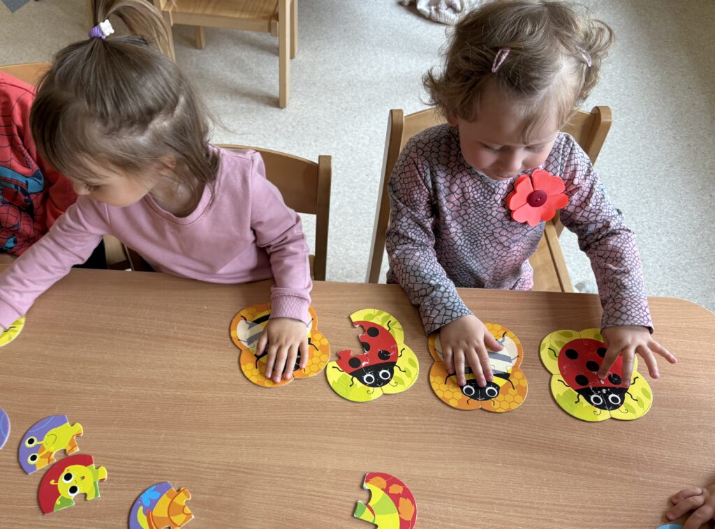 Dziewczynki układają puzzle.