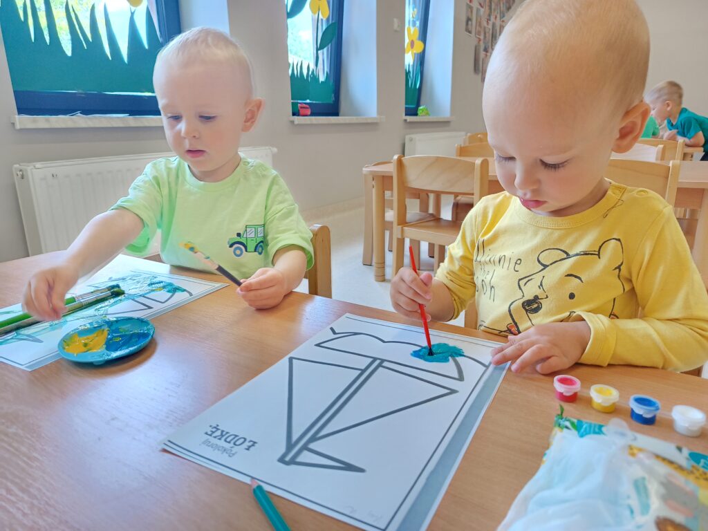 Dzieci malują farbami.